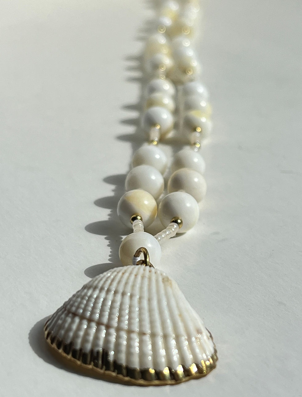 Thumbnail: handmade Mother of Pearl bead necklace with a golden edged shell drop bead