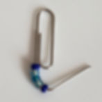 Adding blue glass beads to paper clip