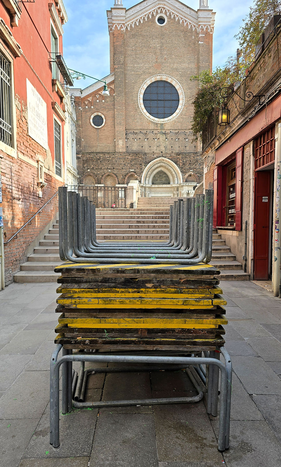 Yellow wooden tables stacked in a Venetian street