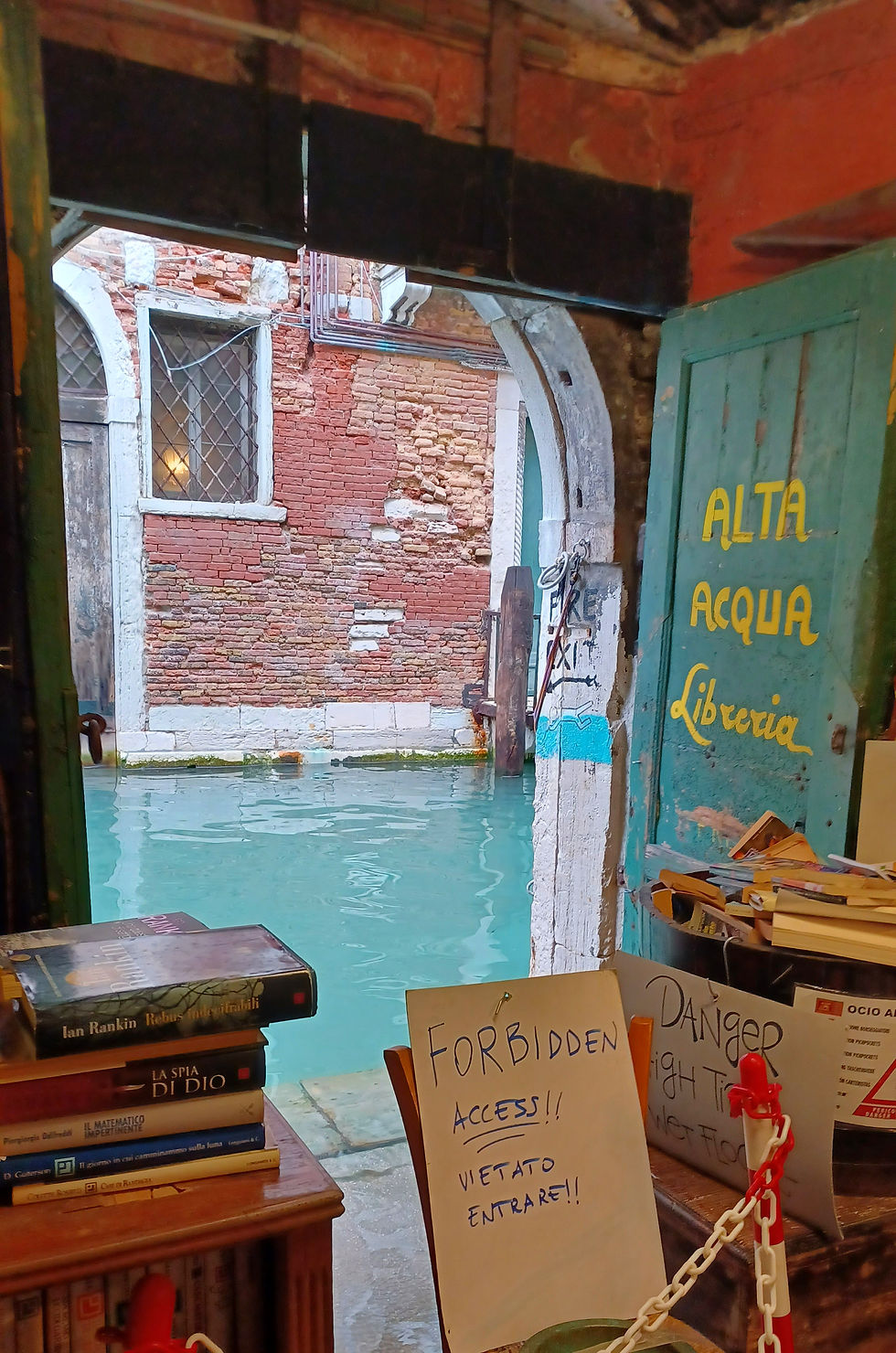 Old bookshop window looking out to a canal in Venice