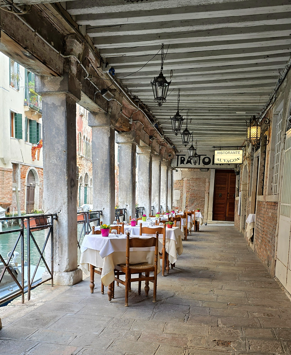 Restaurant tables et near a canal in Venice