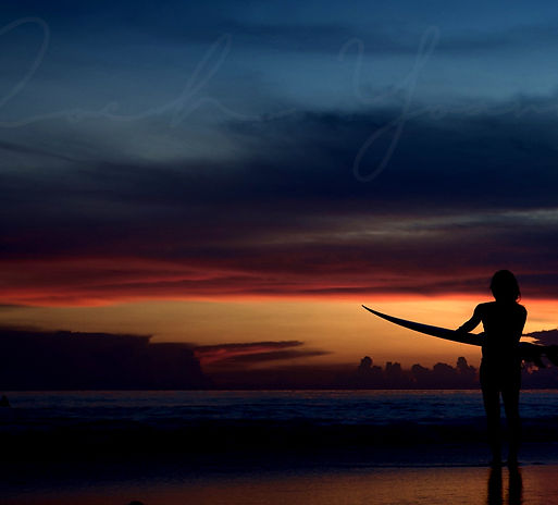 Surfeur sur une plage au coucher de soleil