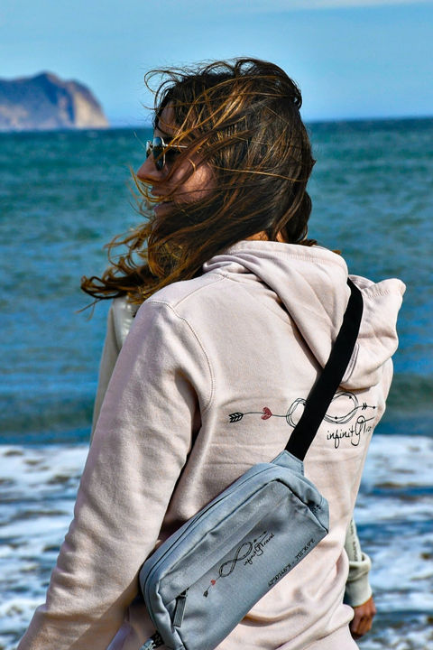 Taya fondatrice de la marque sur une plage d'Aguilas en Espagne portant une banane de la marque infinitytravel.ch