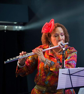 Margaux Simmons plays a flute reading from sheet music on a stand.