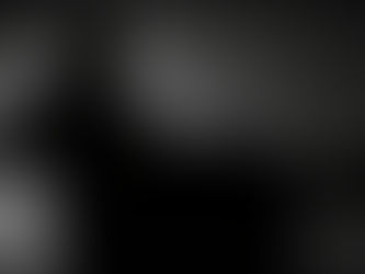 Jameson Dwayne seated in a dark armchair with crossed legs beneath a soft cinematic backlight