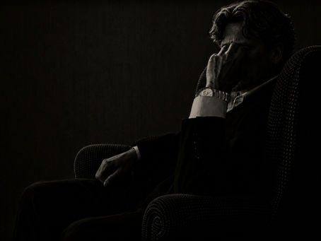 Cinematic portrait of Jameson Dwayne reflecting quietly in a shadowed armchair