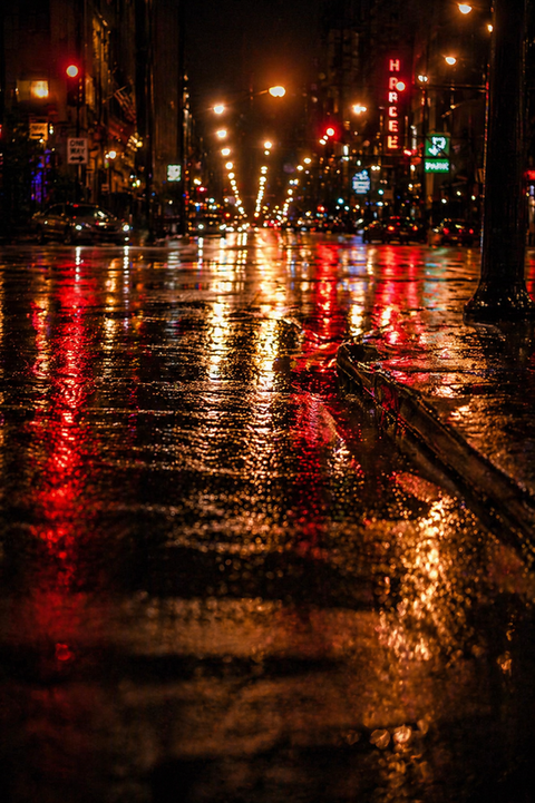 Rain-soaked Chicago street at night with glowing reflections from city lights, cinematic moody atmosphere