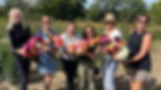 Happy ladies women holding cut flowers in trench field at dahlias as cut flowers workshop
