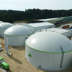 Biogas plant with large dome tanks and industrial buildings.