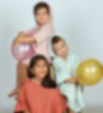 Kids wearing pink, mint and brick colour muslin poncho towel.