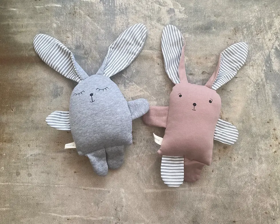 תמונה ממוזערת: שני בובות ארנב תפורות, אחת אפורה ואחת ורודה, עם אוזניים מפוספסות.