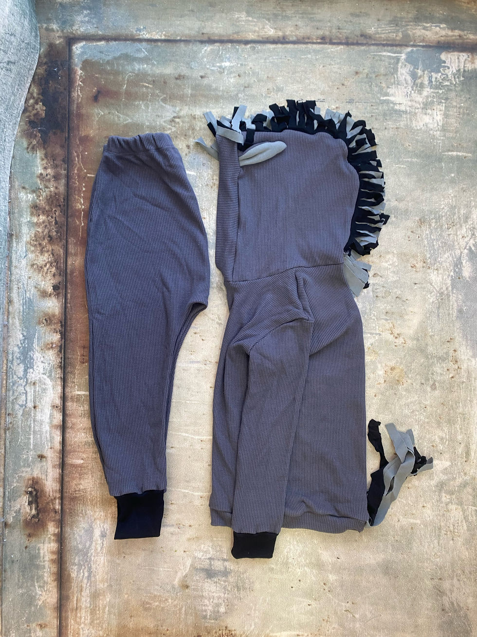 תמונה ממוזערת: תחפושת אפורה לילדים עם קפוצ'ון פרוותי וזנב, מונחת על עץ.