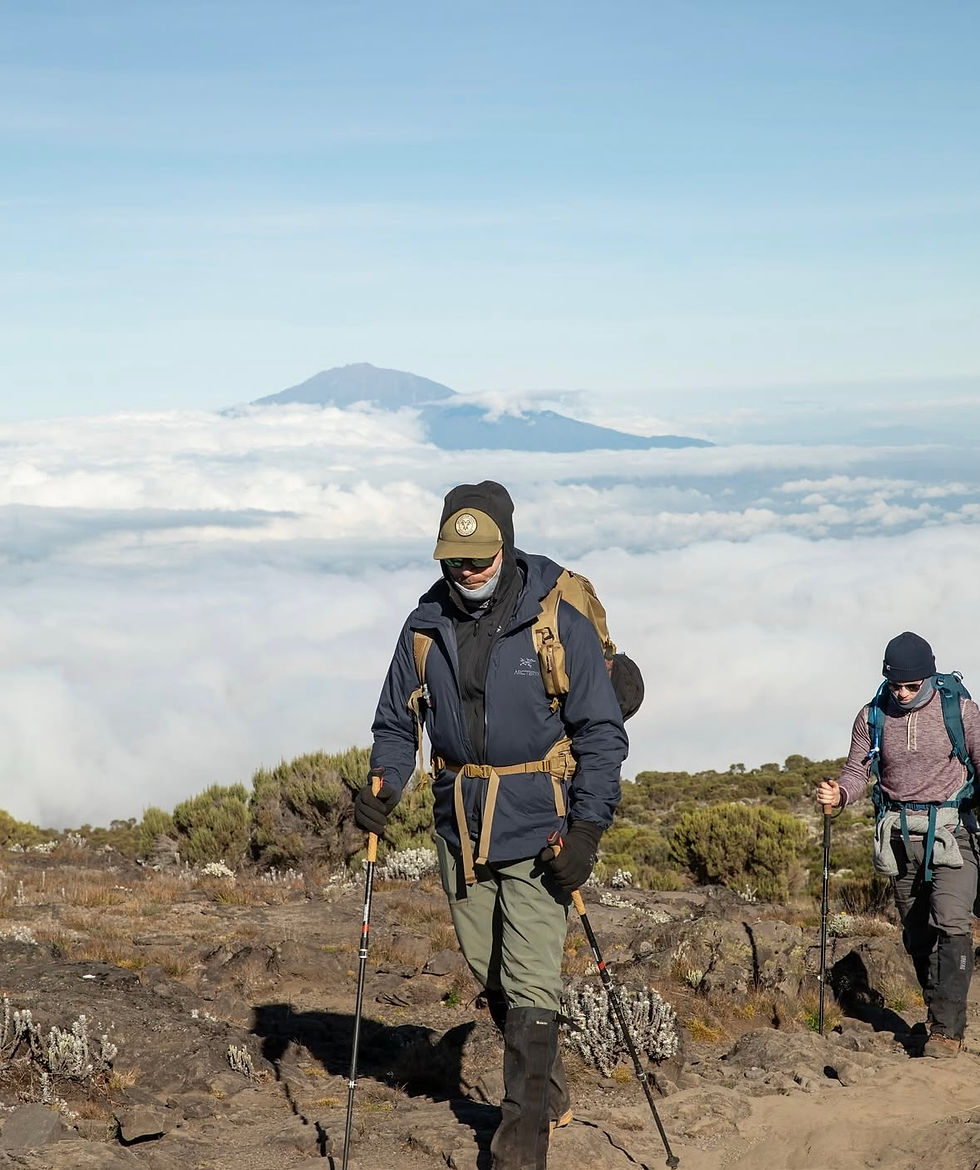 Mountain goat movement hiking mount Kilimanjaro at the top with a backpack on above the clouds