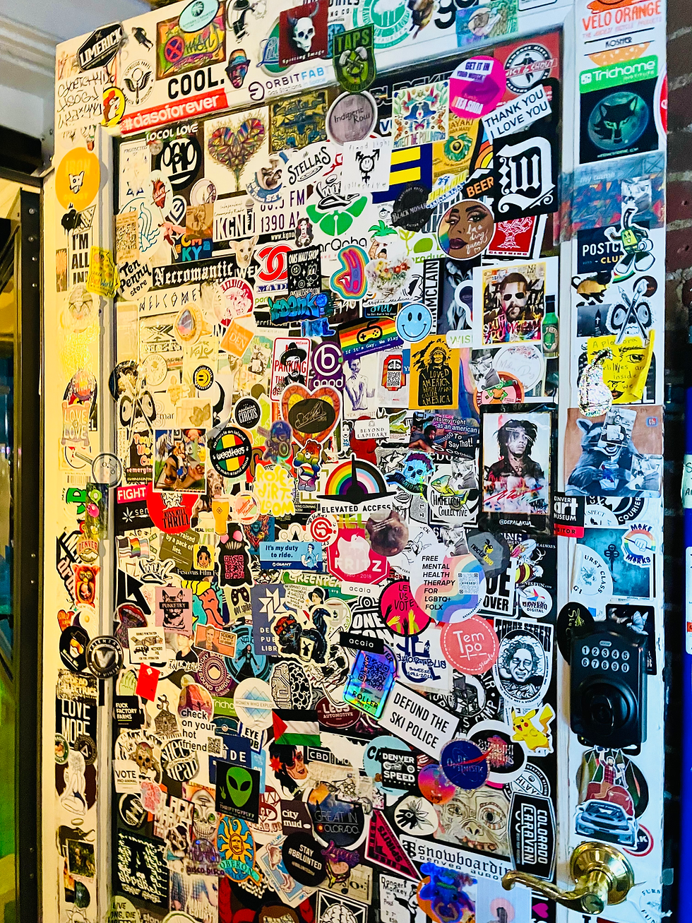 A door at Stella's Coffee House, Denver, CO full of stickers from those who visited it.
