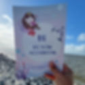 Buch wird in die Luft gehalten an der Nordsee
