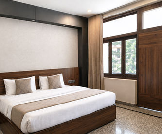Spacious Super Deluxe Room with king bed and window view at Hotel Rajdeep Mount Abu.