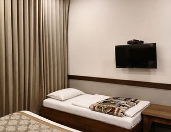 Deluxe room featuring television and comfortable extra bed at Hotel Rajdeep Mount Abu.