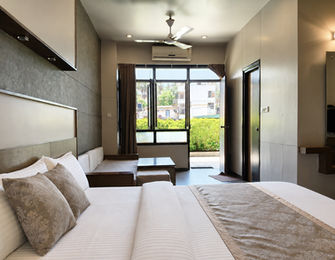 Super Classic Room with king bed and private garden-facing porch at Hotel Rajdeep Mount Abu.