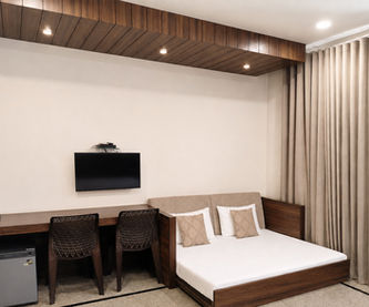 Family-friendly Super Deluxe Room with sofa-cum-bed and king bed at Hotel Rajdeep Mount Abu.