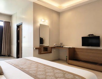 Interior view of Super Classic Room with television and modern furnishings at Hotel Rajdeep Mount Abu.