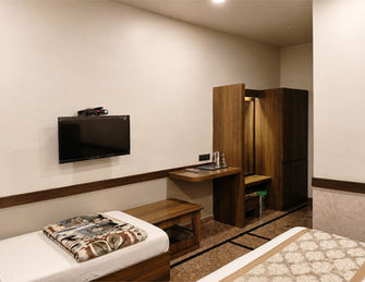 Deluxe room with television, desk and modern amenities at Hotel Rajdeep Mount Abu.