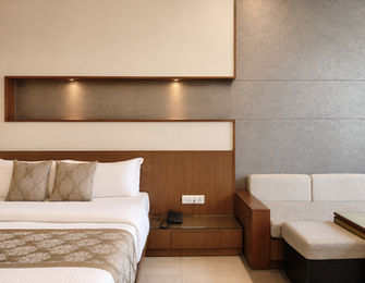 Super Classic Room featuring sofa-cum-bed and comfortable seating area at Hotel Rajdeep Mount Abu.