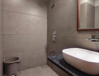 Modern attached bathroom with wash basin in Deluxe Room at Hotel Rajdeep Mount Abu.