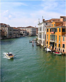 Motorboat and gondolas on a Venice canal lined with historic buildings.