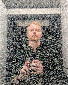 Blond man taking a selfie, reflected in a textured, shimmering surface.