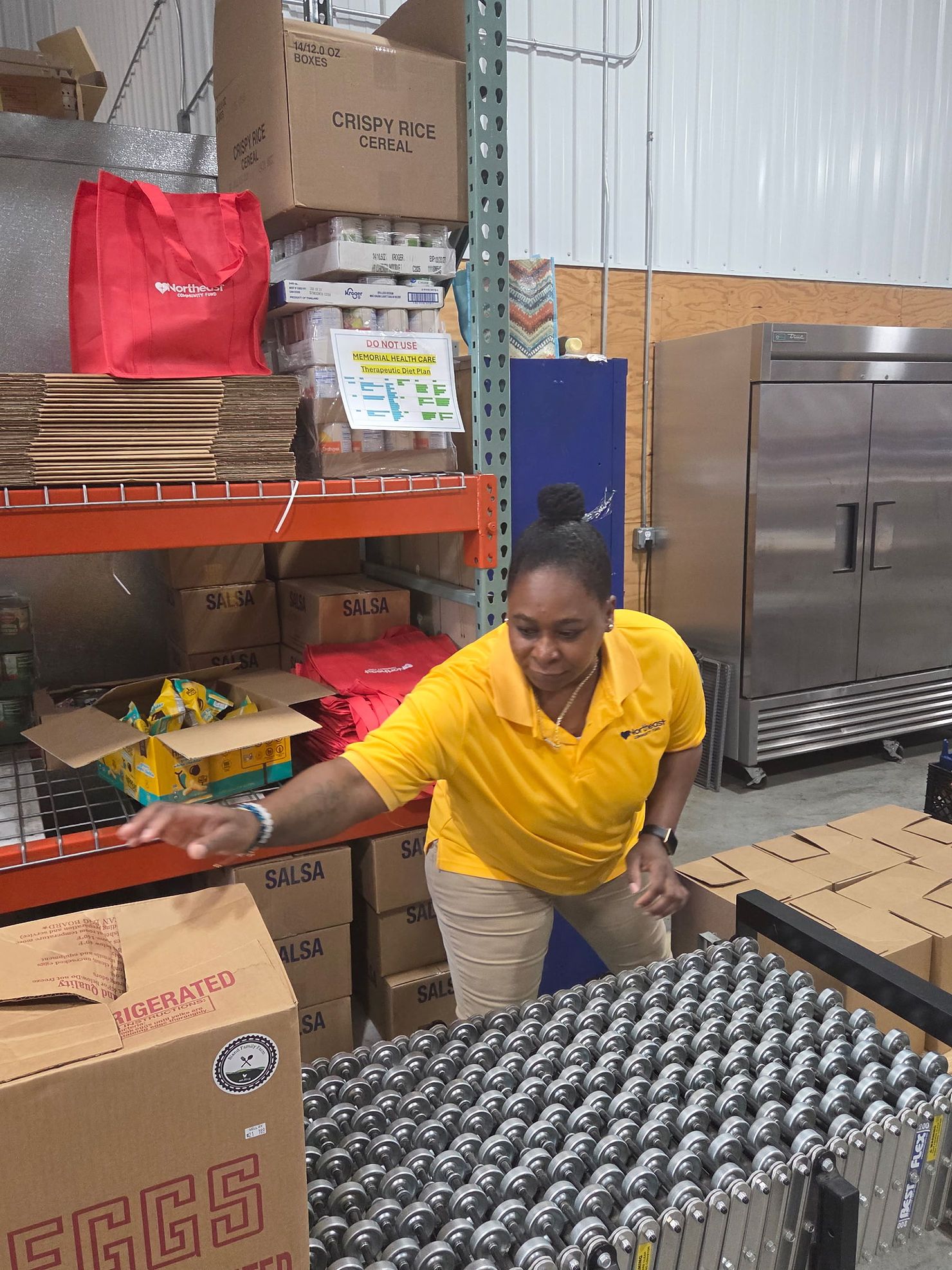 NECF Director Angel Lawrence prepares food boxes at Northeast Community Fund Food Pantry