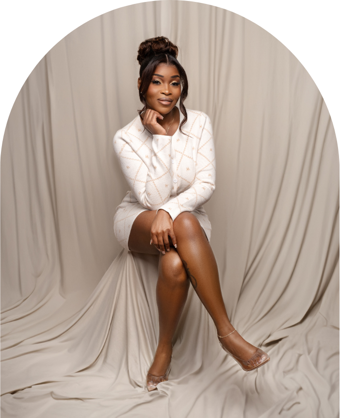 Dr. Ebony Tillery sitting and smiling with a white dress; beige background. The Virtual NP