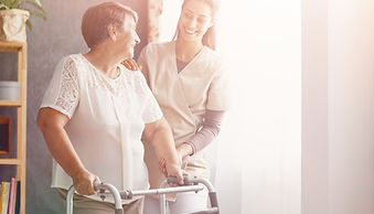 Ältere Dame und Therapeutin beim Training am Rollator