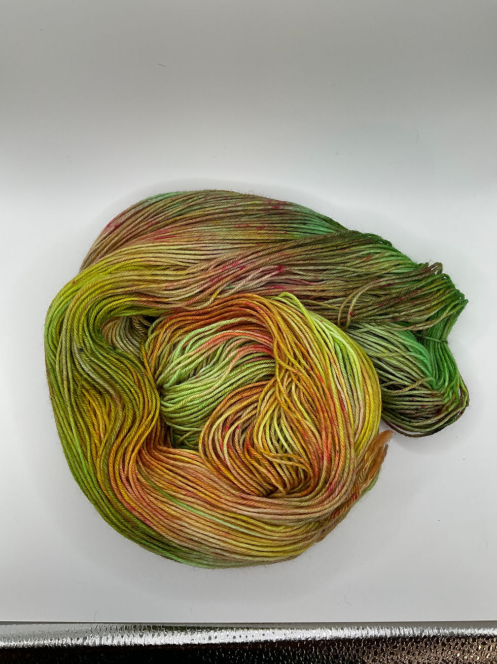 Skein of hand dyed mernio wool yarn yellow, pink and green.