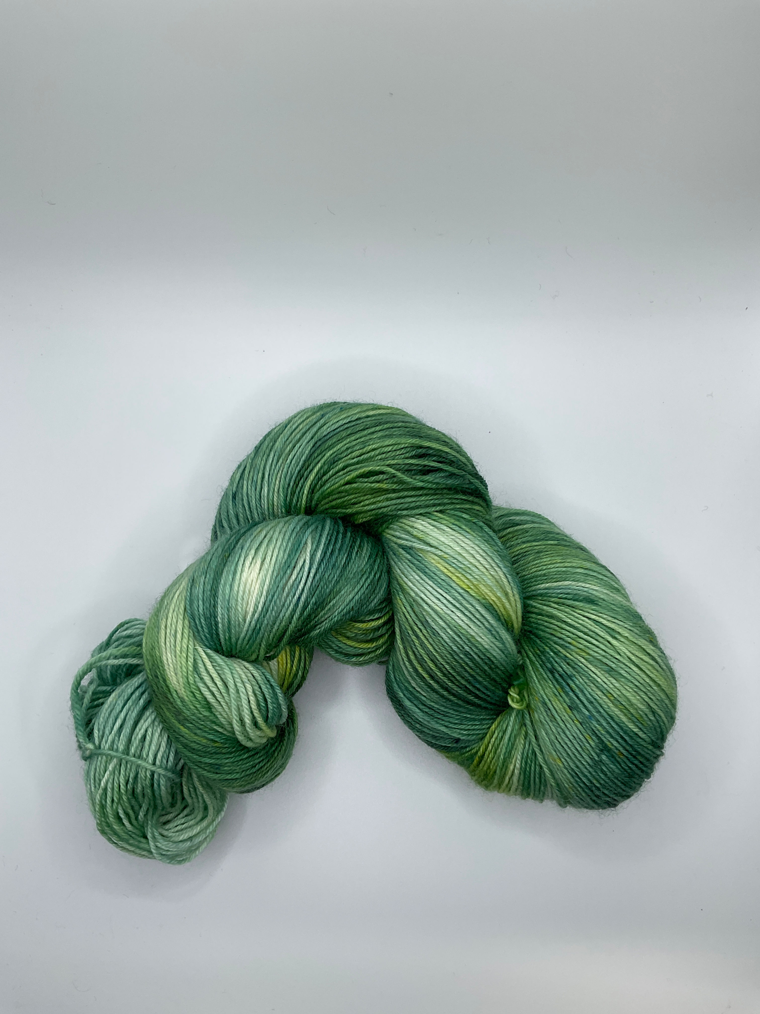One skein hand dyed yarn variegated green.