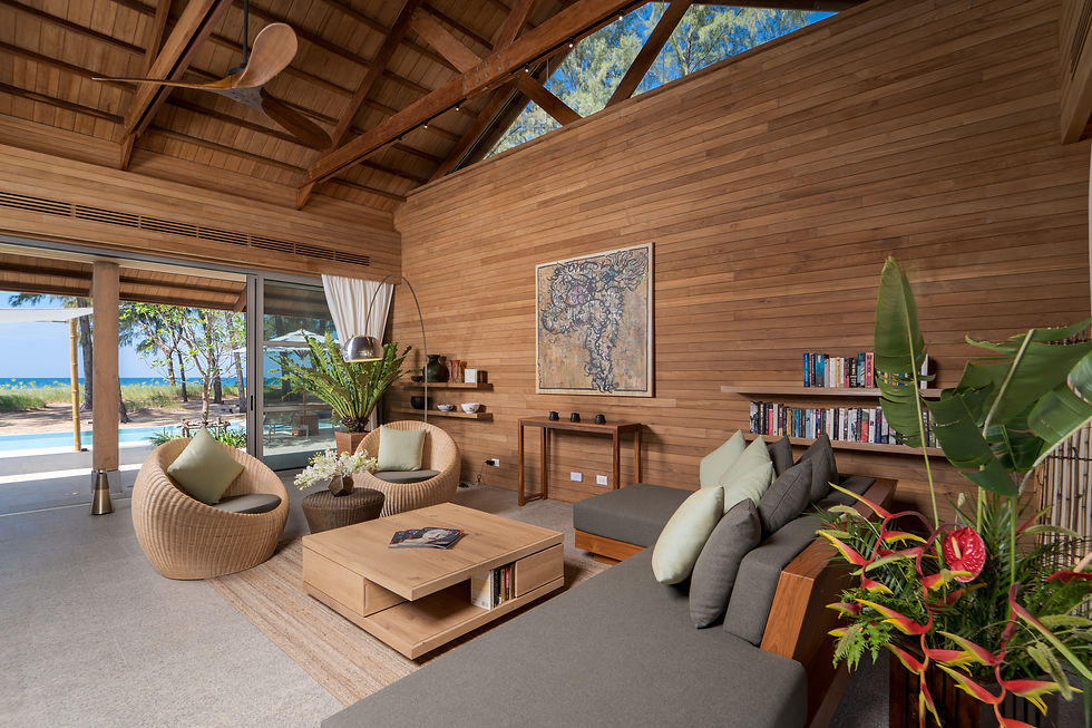 Inviting lounge space with bookshelf, cushioned sofa, wood interior, and island-inspired decor.
