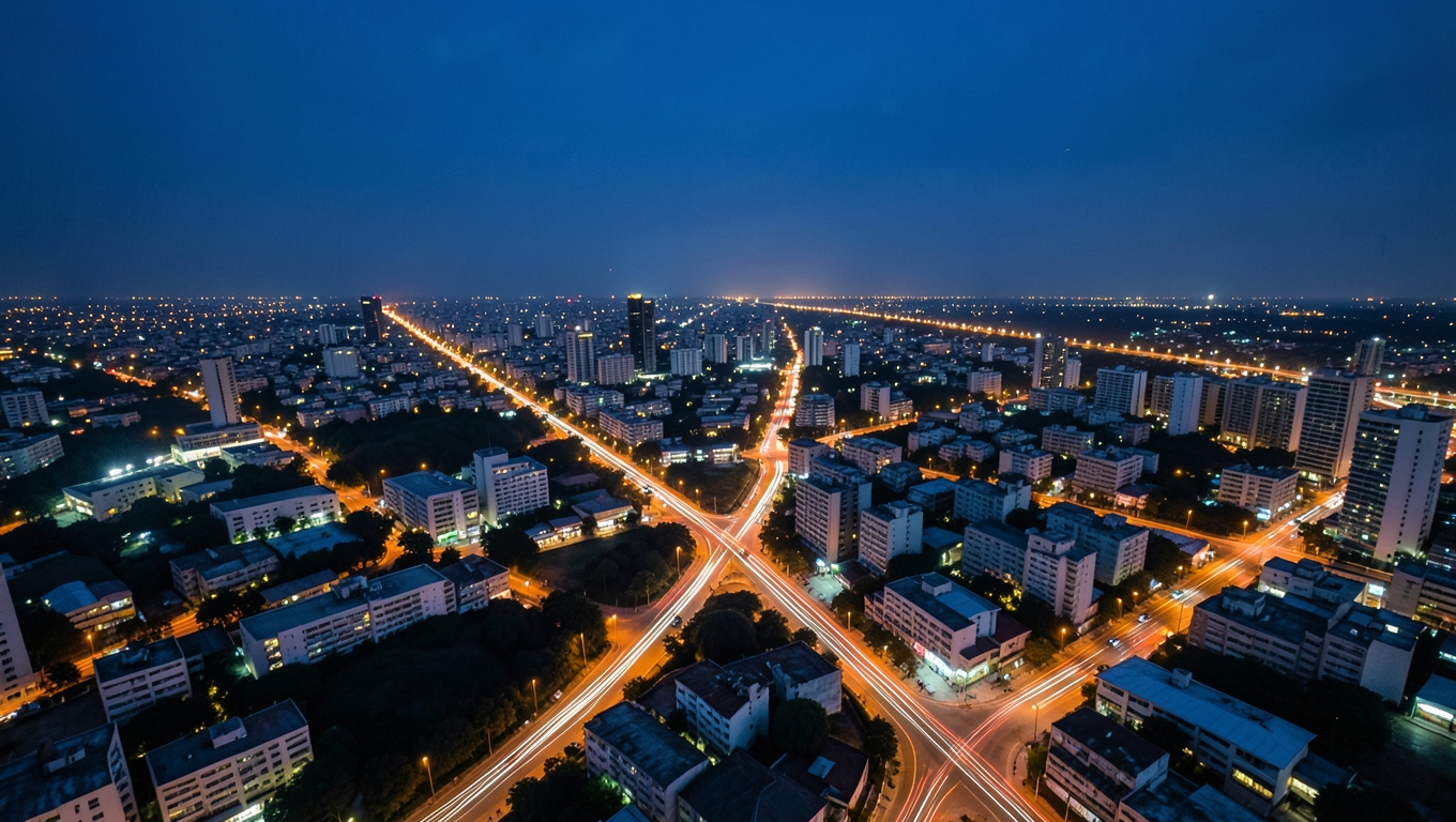 An aerial night view of a city with glowing street lights tracing a network of intersections