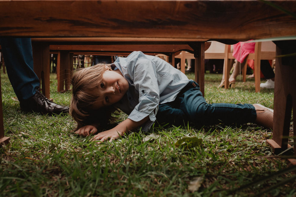criança brincando em baixo da cadeira na cerimonia de casamento