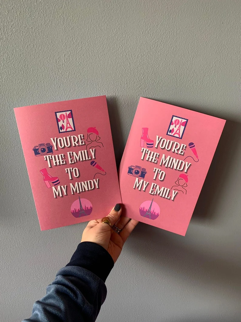 hands holding two matching pink greeting cards