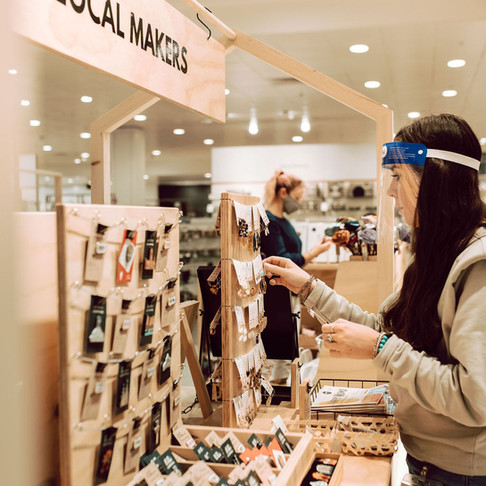A Curated Makers shopfloor team member topping up Pin Head's badge display.