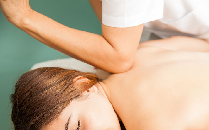 relaxed-young-woman-getting-a-deep-tissue-massage-by-a-female-therapist-at-a-health-clinic