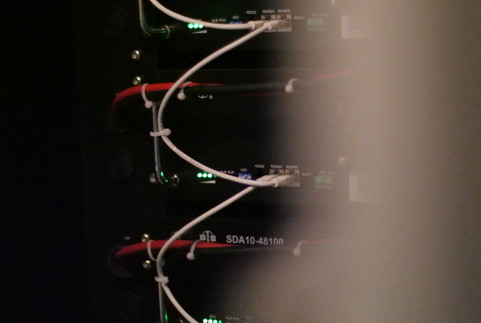 Ett öppet batteriskåp som visar en komplex uppsättning av kretsar, kablar och elektriska komponenter inuti.