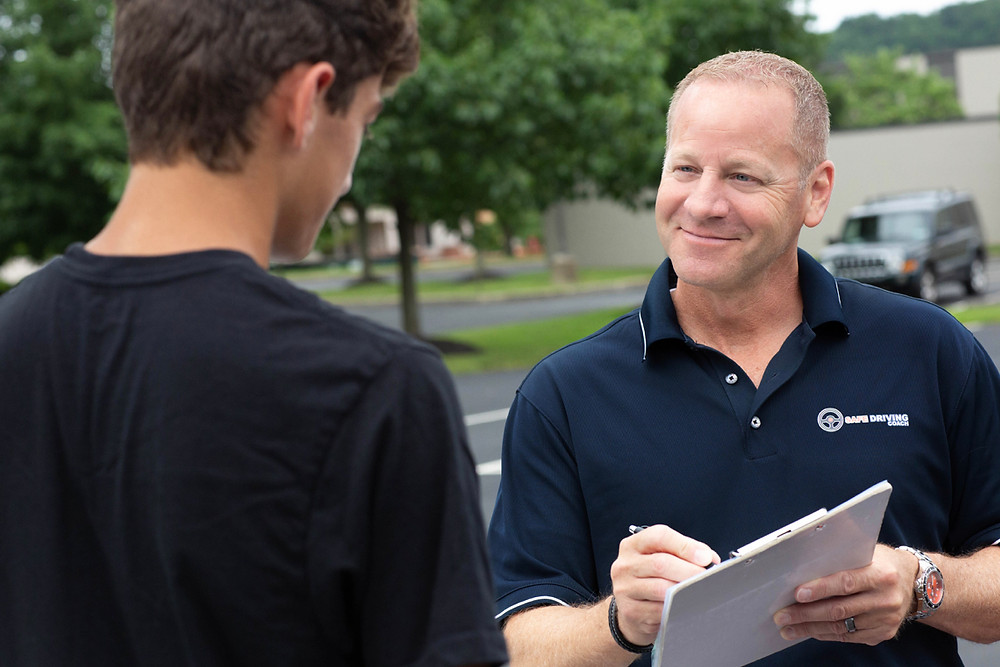 Driving instructor reviewing checklist with new teen driver student