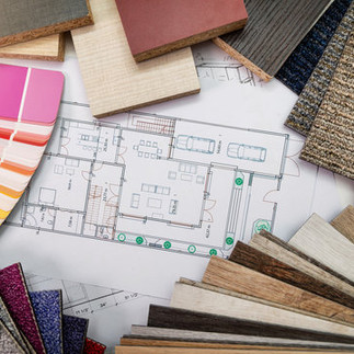 Interior design material samples with fabric swatches, wood flooring, and floor plans – professional decorating services in Frisco Texas