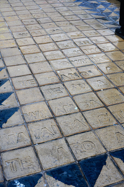 Close up of public park sculpture tiles in foreground. Artist Shona Rapira-Davies.