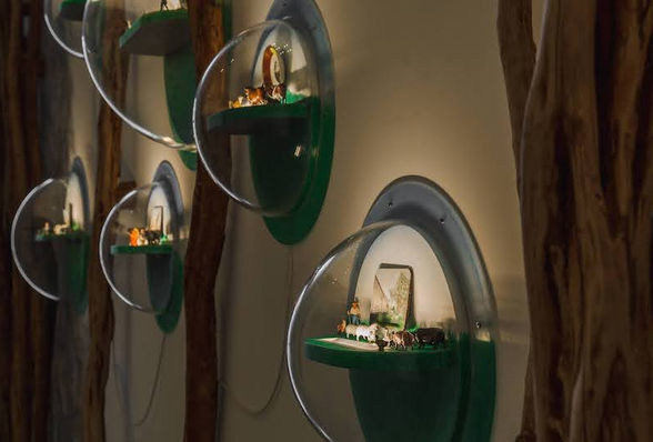 Sculpture of maori palisades with small bubble windows showing military figurines.