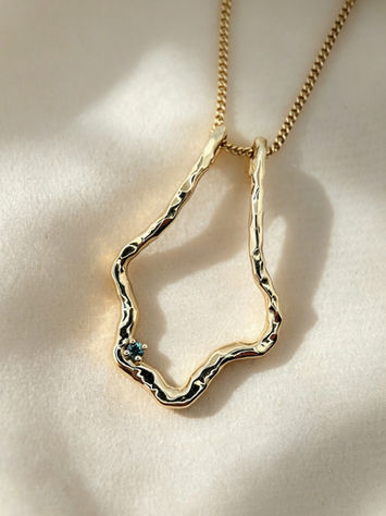9ct yellow gold organic hammered ring keeper with a delicate teal-blue sapphire, the bride’s birthstone.