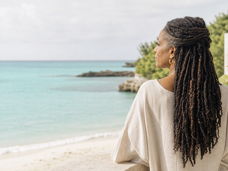 Femme noire aux locks en vacances au bord de la mer, conseils KJ LOCKS pour protéger ses locks