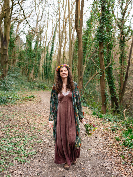 Bride walking in Hastings, Sussex, UK, forest after getting married. 