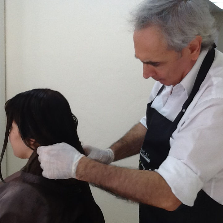 Master hair colorist Leonardo attends to a client during a hair color correction session