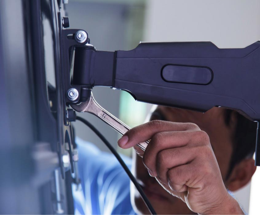 A Precision Connect team member installing TV mounting equipment